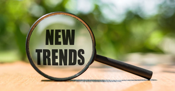 Magnifying glass focusing on new trends text symbolizing 2025 wellness trends for stress relief innovations