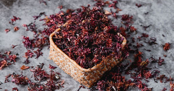 Dried herbal ingredients in a woven basket for organic sea moss pills supplement preparation
