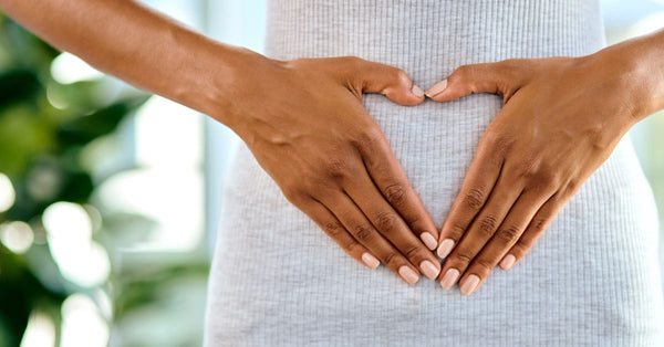 Person forming a heart shape with hands over their stomach representing how does the microbiome affect sleep
