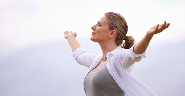 Woman outdoors enjoying calm moment representing natural supplements for stress relief and relaxation