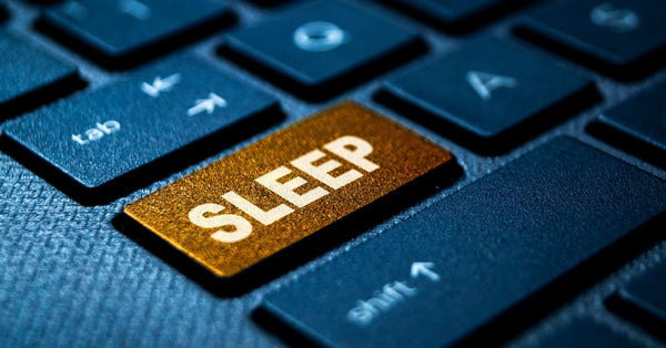 Close-up of keyboard with a gold sleep key representing quality vs quantity of sleep explained