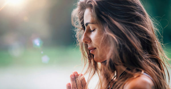 Woman practicing meditation outdoors to learn how does stress affect your health and manage it naturally