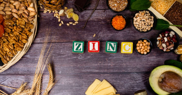 Various zinc-rich foods arranged around blocks spelling zinc and highlighting how does zinc affect stress levels